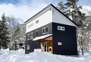 白马村Hakuba Views的雪中黑白的房子