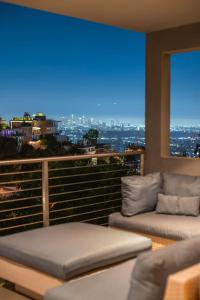 洛杉矶6MIL 5BR Sunset Strip Villa Jetliner Views Oasis的阳台设有两张沙发,享有城市美景。