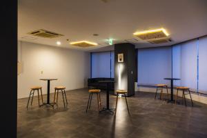 米子市米子シティガーデンズホテル Yonago Citygardens Hotel的一间设有凳子和桌子的房间,房间设有钢琴