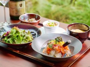 福冈The Royal Park Canvas Fukuoka Nakasu的一张桌子,上面放着两碗食物和一盘沙拉
