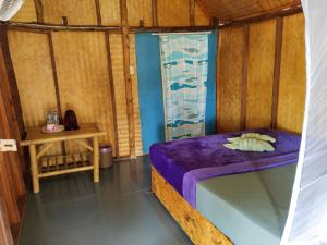 高兰安达曼湾简易别墅的小房间设有一张床和一张桌子
