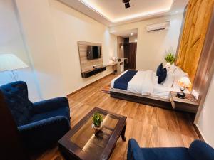 瑞诗凯诗Ganges Blossam, Haridwar-Rishikesh Road - A Four Star Luxury Hotel的一间卧室设有一张床和一间客厅。