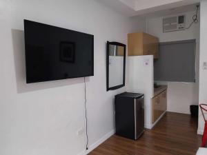 安吉利斯Regal425 Condotel的带冰箱的厨房和墙上的电视
