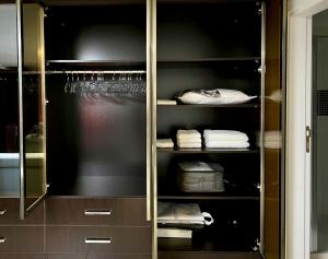 穆达尼亚NEW Seaview Bachelor Apartment Privacy + Closets的衣柜配有带毛巾的玻璃柜