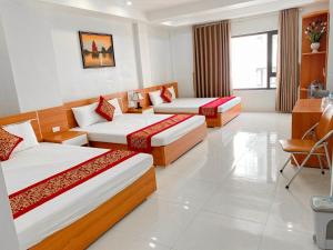 下龙湾Sail Hotel Hạ Long的酒店客房配有两张床和一张书桌