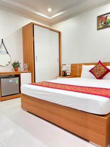 下龙湾Sail Hotel Hạ Long的一间带大床和电视的卧室