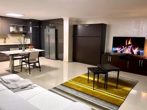 穆达尼亚NEW Seaview Bachelor Apartment Privacy + Closets的厨房以及带桌子和壁炉的用餐室。