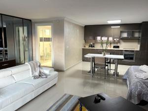 穆达尼亚NEW Seaview Bachelor Apartment Privacy + Closets的客厅配有白色的沙发和桌子