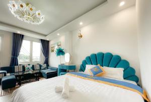 大叻和美酒店的一间卧室配有一张大床和蓝色床头板