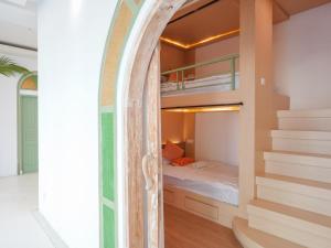 龙目岛库塔Puri Rinjani Bungalows & Hostel的一间卧室设有双层床和楼梯。