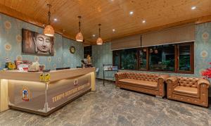 甘托克Treebo Premium Tempo Heritage Spa & Resort的一间设有棕色皮革家具和柜台的等候室