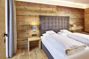 埃尔瓦尔德der grüne Baum Mountain Boutique Hotel的卧室设有两张木墙