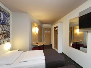 柏林B&B HOTEL Berlin-Alexanderplatz的配有一张床和一张书桌的酒店客房