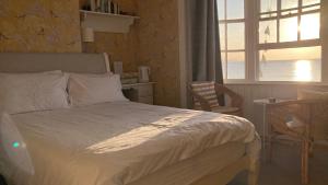 韦茅斯白色悬崖宾馆的一间卧室设有一张床、一个窗口和一张桌子