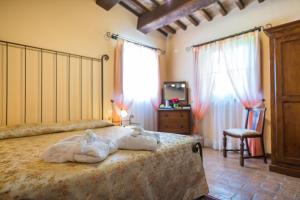 德鲁塔Hotel & SPA L'Antico Forziere的一间卧室配有一张床、一把椅子和窗户。