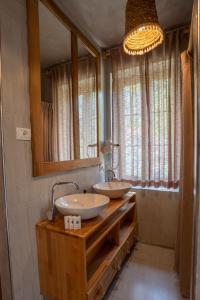 泰斯Hotel Restaurant Alpet Theth的一间带两个盥洗盆和大镜子的浴室