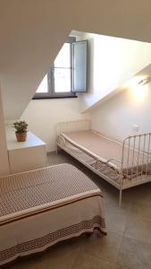 菲纳莱利古雷Mansarda Cavassola的客房设有两张床和窗户。