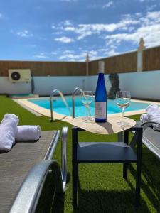 卡勒达德福斯特Beach Villa private heated pool的一张桌子上放着一瓶葡萄酒,放上两杯