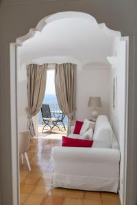 波西塔诺麦润科图酒店的客厅配有白色沙发,享有海景