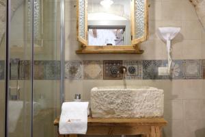 阿尔贝罗贝洛Trulli Soave的浴室配有盥洗盆和带镜子的淋浴