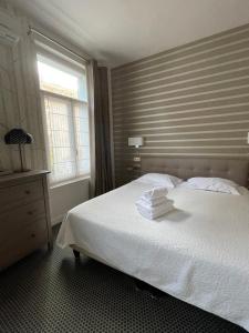 维希Le Pavillon d'Enghien, Vichy Centre的卧室配有白色床和毛巾