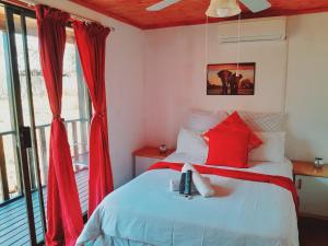 MkuzeIgula lodge的一间卧室配有红色窗帘的床