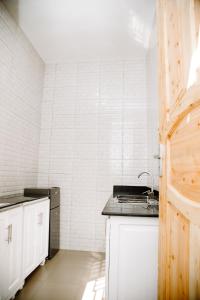 达累斯萨拉姆ESN LODGES & HOMETSAY SERVICES的厨房设有水槽和白色瓷砖墙。