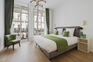 巴黎Vestay Montaigne的一间卧室配有一张大床和一张绿色椅子