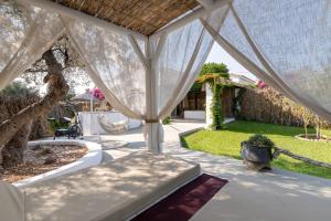 科林比亚Elefteria Apts & Suites的一个带白色天篷和花园的庭院
