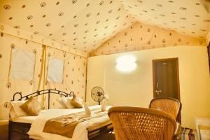 斋沙默尔Destination Desert Camp的一间卧室,卧室内配有一张床和椅子