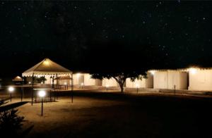 斋沙默尔Destination Desert Camp的夜间公园,有天篷和游乐场