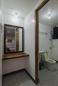 马尼拉Marion Hotel的一间带镜子和卫生间的浴室