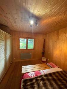 马泰马尔Chalet Familial的木制客房内的一间卧室,配有一张床
