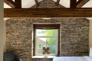 哈利法克斯Croft House Cottage的一间卧室设有石墙和窗户。