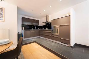 蒙斯Luxury Duplex Coeur de Mons 64-3的厨房配有不锈钢用具和桌子