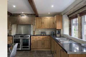 哈利法克斯Croft House Cottage的厨房配有木制橱柜和炉灶烤箱。