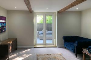 哈利法克斯Croft House Cottage的客厅设有蓝色的沙发和滑动玻璃门