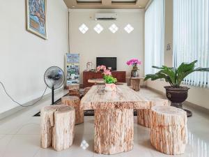 KinatiRedDoorz Plus Syariah near Simpang Rimbo Jambi的客房设有带凳子的桌子和风扇。