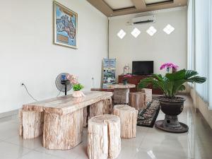 KinatiRedDoorz Plus Syariah near Simpang Rimbo Jambi的一间设有一张桌子和一些木凳的房间