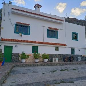 Balcon de TeldeCasa Mami Carmen Telde, Las Palmas的前面有盆栽植物的白色房子