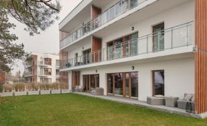 贡斯基LET'S SEA - 2 Bedroom - Premium Baltic Apartment with Garden and Sea View的公寓大楼前面设有草坪