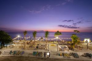 吉利特拉旺安FRii Resort Gili Trawangan的夜晚享有海滩美景,配有灯光