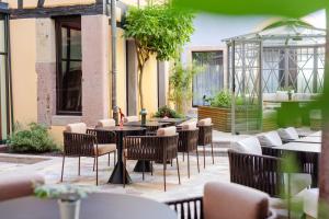 科尔马Hotel Le Colombier的餐厅内带桌椅的庭院