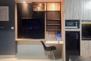 CikeasRedLiving Apartemen Royal Sentul Park - Budi Property的一张黑椅,坐在一个窗户的房间