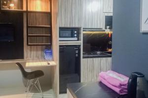 CikeasRedLiving Apartemen Royal Sentul Park - Budi Property的一间配备了黑色冰箱和微波炉的小厨房