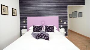 索伦托Bella Sorrento B&B的卧室配有一张白色大床和粉红色床头板