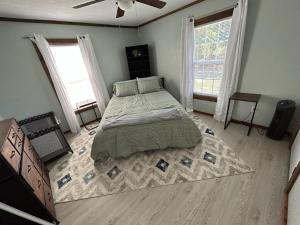 QuitmanLake Fork Fishing Getaway的一间卧室设有一张大床和两个窗户。