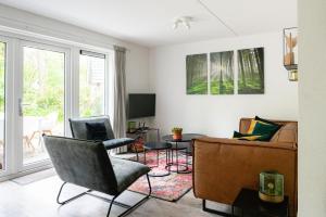 宁斯佩特Luxe Vakantiehuis Grove Den Veluwe的客厅配有沙发和椅子
