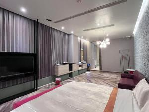 台中市天月人文休闲汽车旅馆 的一间卧室配有一张大床和一台平面电视