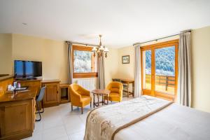 奥尔迪诺Abba Ordino Babot Hotel的一间卧室配有一张床、一张书桌和一台电视
